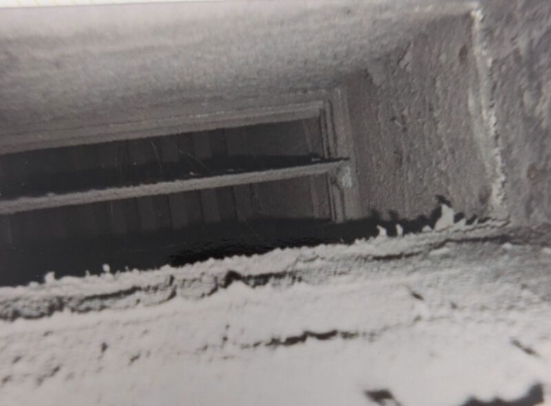 Dust-caked air duct interior before cleaning